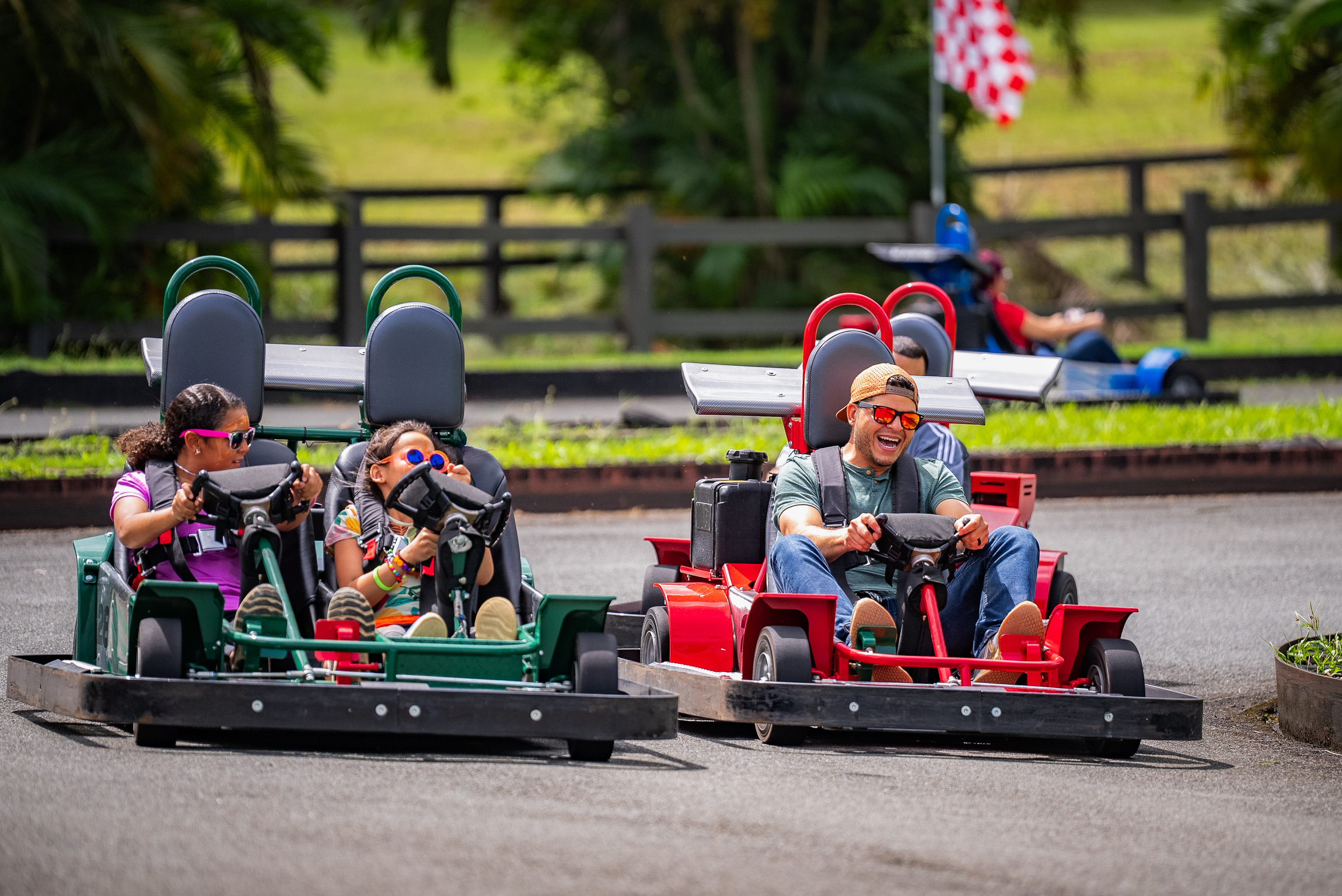 People enjoying go-kart racing on a sunny day.