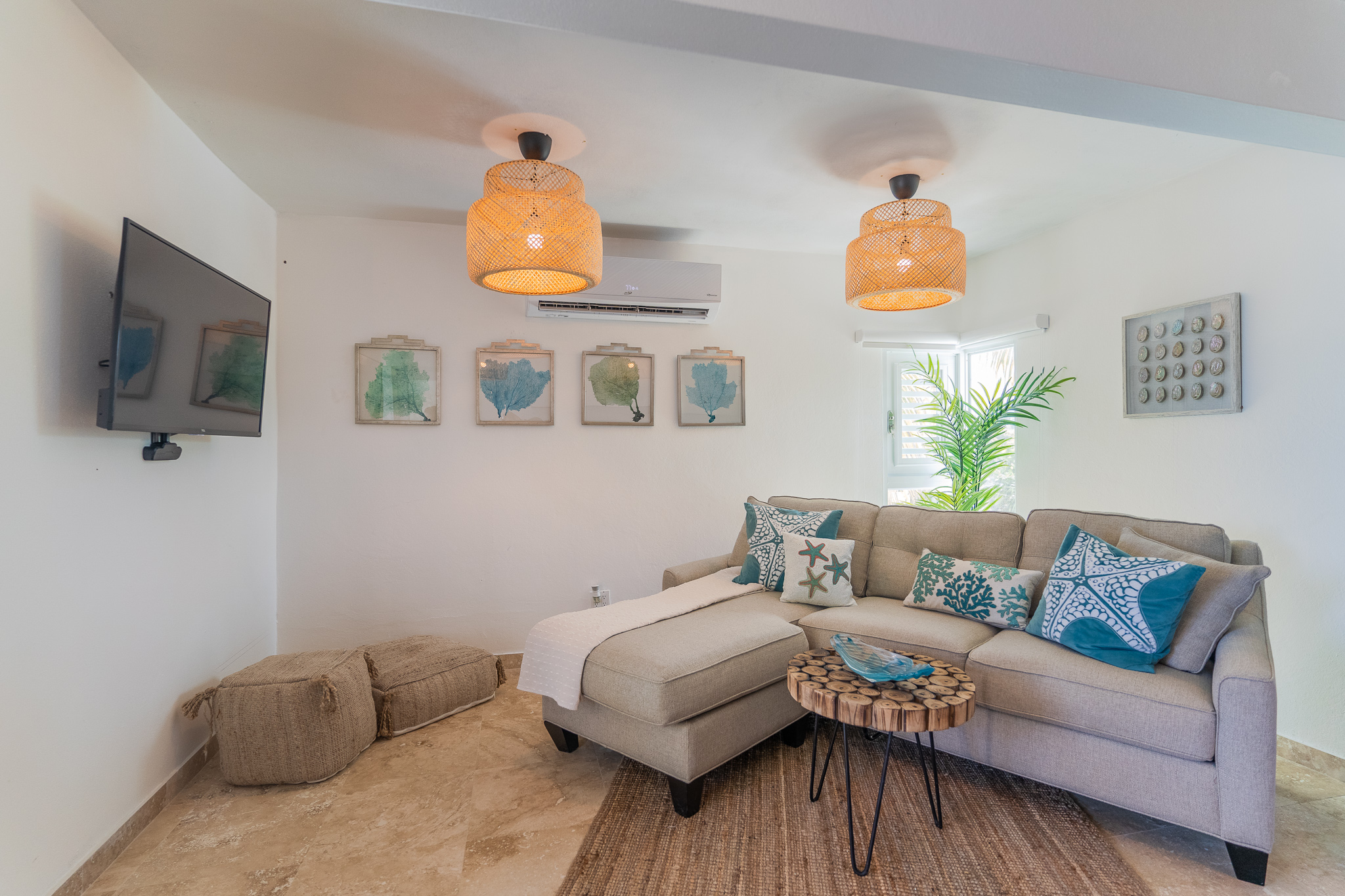 Cozy living room with gray sectional sofa, wicker lamps, and wall art.